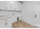 Clean laundry room features modern cabinetry, granite countertops, utility sink, and door to outside at 1300 Austin Chaney Rd, Wingate, NC 28174
