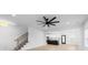 Open-concept living room with light wood floors, modern fan, stairway and view into kitchen at 1300 Austin Chaney Rd, Wingate, NC 28174