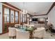 Elegant dining room with a glass table, cushioned chairs, chandelier, and abundant natural light with a view of the living room at 1816 Country Garden Dr, Shelby, NC 28150