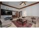 Cozy living room featuring a large TV, comfortable seating, a ceiling fan, and wood trim with an opening to the dining room at 1816 Country Garden Dr, Shelby, NC 28150