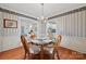 Elegant dining room with a glass-top table and seating for four, adjacent to the living room and kitchen at 1911 Connemara Ct, Gastonia, NC 28054
