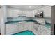 Well-lit kitchen showcases white cabinetry, turquoise countertops and flooring, plus modern appliances at 1911 Connemara Ct, Gastonia, NC 28054