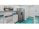 Efficient kitchen featuring stainless steel refrigerator, white appliances, and colorful turquoise floors at 1911 Connemara Ct, Gastonia, NC 28054