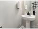 Powder room featuring a pedestal sink and stylish mirror at 19113 Hawk Haven Ln, Charlotte, NC 28278