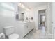 Well-lit bathroom with double vanity, white cabinets, and a large mirror at 19113 Hawk Haven Ln, Charlotte, NC 28278