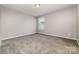 A neutrally painted bedroom features plush carpeting and a window for natural light at 19113 Hawk Haven Ln, Charlotte, NC 28278