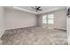 A bright bedroom features plush carpeting, neutral walls and a ceiling fan with natural light from the windows at 19113 Hawk Haven Ln, Charlotte, NC 28278