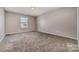This carpeted bedroom features a neutral paint and a window for natural light at 19113 Hawk Haven Ln, Charlotte, NC 28278