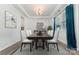 Bright dining room featuring a modern chandelier, a large wooden table and chairs, and neutral decor with blue accents at 19113 Hawk Haven Ln, Charlotte, NC 28278