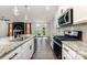 Bright kitchen featuring granite countertops, stainless steel appliances, and an open layout flowing into the living area at 19113 Hawk Haven Ln, Charlotte, NC 28278