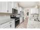 Modern kitchen with stainless steel appliances, granite countertops, white cabinets, and hardwood-style floors at 19113 Hawk Haven Ln, Charlotte, NC 28278