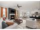 Open-concept living room with fireplace, ceiling fan, modern furnishings, and adjacent kitchen with bar seating at 19113 Hawk Haven Ln, Charlotte, NC 28278