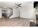 Bright living room with fireplace, ceiling fan, LVP flooring, stairs, and neutral paint at 19113 Hawk Haven Ln, Charlotte, NC 28278
