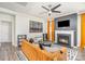 Inviting living room with a fireplace, stylish furniture, a modern ceiling fan, and hardwood-style floors at 19113 Hawk Haven Ln, Charlotte, NC 28278