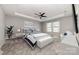 Spacious main bedroom with tray ceiling, ceiling fan, large window, and neutral decor with blue accents at 19113 Hawk Haven Ln, Charlotte, NC 28278
