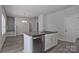 Kitchen island featuring a stainless-steel dishwasher, white cabinets, and granite countertops at 2101 Arapaho Dr, Charlotte, NC 28214