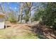 Spacious backyard featuring mature trees, a storage shed, and a mix of grass and shaded areas at 2727 Hilliard Dr, Charlotte, NC 28205