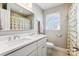 Bathroom featuring a double sink vanity, a window, and a shower with a patterned shower curtain at 2727 Hilliard Dr, Charlotte, NC 28205