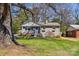 Charming gray brick home featuring a well-maintained lawn, blue door and inviting curb appeal at 2727 Hilliard Dr, Charlotte, NC 28205