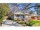 Charming gray brick home featuring a well-maintained lawn, blue door and inviting curb appeal at 2727 Hilliard Dr, Charlotte, NC 28205