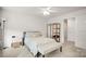 Cozy bedroom featuring neutral colors, a comfortable bed, bench, and a white nightstand at 3878 Fairlady Ln, Fort Mill, SC 29707
