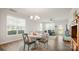 Bright dining area with large windows and modern lighting fixtures, flowing into the living room at 3878 Fairlady Ln, Fort Mill, SC 29707