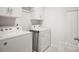 Efficient laundry room equipped with modern, white appliances and ample storage space at 3878 Fairlady Ln, Fort Mill, SC 29707