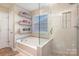 Serene bathroom with tub, glass shower, and built-in shelves by the window at 4214 High Shoals Dr, Monroe, NC 28110