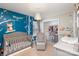 Charming Bedroom featuring a crib, rocker, changing table, and playful wall decorations at 4214 High Shoals Dr, Monroe, NC 28110