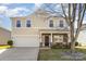 Beautiful home featuring a two-car garage, stone accents, a manicured lawn and a welcoming front porch at 4214 High Shoals Dr, Monroe, NC 28110