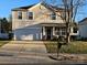 Charming two-story home features a well-manicured lawn, attached two-car garage, and a welcoming front porch at 4214 High Shoals Dr, Monroe, NC 28110