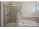 Modern bathroom featuring a glass-enclosed shower, soaking tub, and neutral decor at 4246 Millstream Rd, Denver, NC 28037