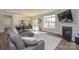 Bright living room with a fireplace, dining area, hardwood floors, and a comfortable gray sofa at 4246 Millstream Rd, Denver, NC 28037