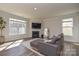 Cozy living room with a fireplace, large windows, and a comfortable gray sectional sofa at 4246 Millstream Rd, Denver, NC 28037