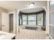 Bright bathroom featuring large garden tub with column accents and tile flooring at 4825 1St Street Nw Ct, Hickory, NC 28601