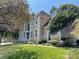Elegant two-story home featuring a stucco facade, white trim, arched windows and lush green lawn and mature trees at 4825 1St Street Nw Ct, Hickory, NC 28601