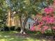 Charming home with lush landscaping featuring mature trees and vibrant pink flowers, providing a picturesque setting at 4825 1St Street Nw Ct, Hickory, NC 28601