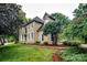 Stately home with manicured lawn, mature trees, stucco facade, white trim and arched windows at 4825 1St Street Nw Ct, Hickory, NC 28601