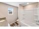 Well-lit bathroom features a shower-tub combination, granite vanity, and a window at 509 Holly St, Statesville, NC 28677