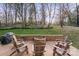 Inviting backyard features a brick patio with chairs and fire pit for outdoor enjoyment at 5421 Woodcreek Dr, Charlotte, NC 28226