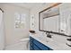 Bright bathroom featuring blue vanity with framed mirror and well-lit vanity at 5421 Woodcreek Dr, Charlotte, NC 28226
