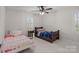 Comfortable bedroom featuring neutral walls, ceiling fan, and two twin beds near window at 5421 Woodcreek Dr, Charlotte, NC 28226