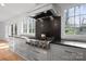 Modern KitchenAid gas range and stainless steel vent hood complement the custom cabinets at 5421 Woodcreek Dr, Charlotte, NC 28226