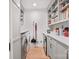 Well-lit laundry room with white cabinetry, countertop, washer, dryer, shelving, and hardwood floors at 5421 Woodcreek Dr, Charlotte, NC 28226