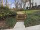 Inviting brick walkway with steps leading to a charming white house with a manicured lawn at 5421 Woodcreek Dr, Charlotte, NC 28226