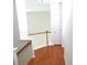 Upstairs hallway featuring wood floors, staircase access, and a white door at 5963 Pale Moss Ln, Charlotte, NC 28269