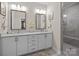Bathroom featuring double sinks, a walk-in shower, and modern fixtures at 6015 Pleasant Run Dr, Matthews, NC 28104
