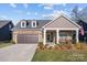 Charming home featuring a two-car garage, manicured lawn, and inviting front porch area at 6015 Pleasant Run Dr, Matthews, NC 28104