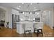 Bright eat-in kitchen boasts white cabinets, stainless steel appliances, and an island with bar seating at 6015 Pleasant Run Dr, Matthews, NC 28104