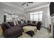 Spacious living room with a large sectional sofa, ottoman, and a view into the open kitchen at 6015 Pleasant Run Dr, Matthews, NC 28104